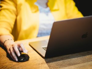 person in yellow dress shirt using black laptop computer