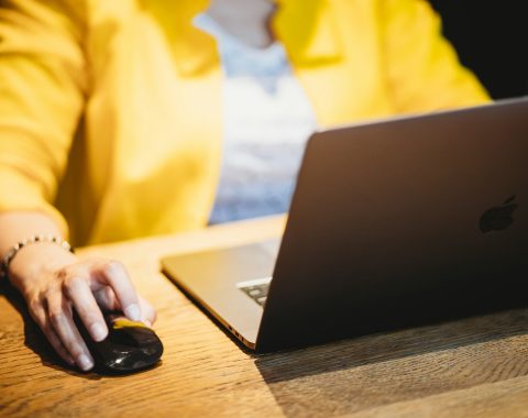 person in yellow dress shirt using black laptop computer